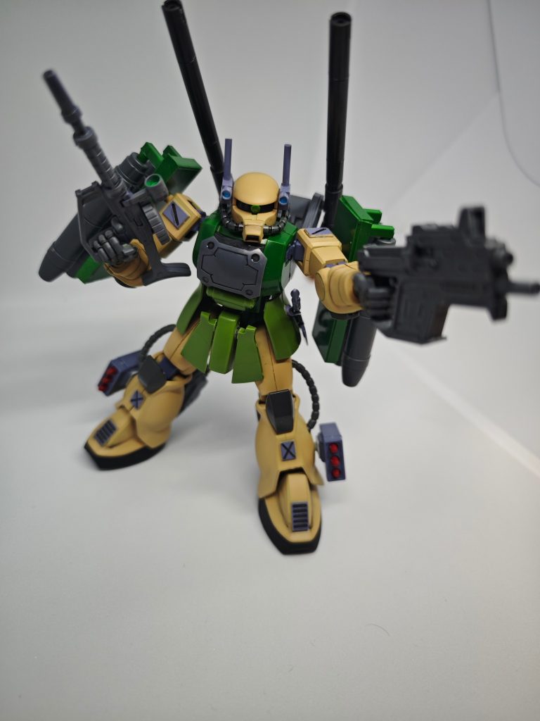元は旧HGのザクをベースにショルダーシールドはプラ板で新規製造しました。頭部はプラ棒でセンサーを増やしカメラアイはレンズパーツを使用していますボディや肩部、脛などに装甲を追加してそれっぽくしております。