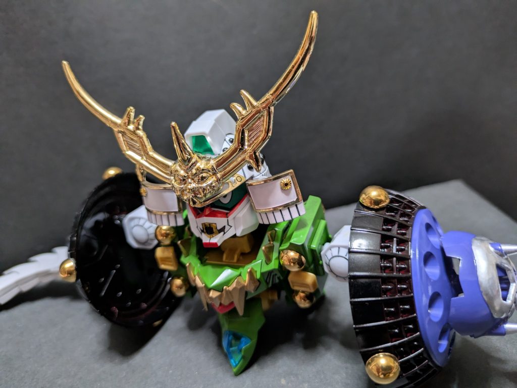 口裂けをどう再現するか…最も難航した頭部。２キットの頭部を潰した試作の末、「LGBB二代目頑駄無大将軍」のバトルマスクを利用した差し替えで再現に漕ぎ着けました。牙は塗装では目立たなかったのでホイルシールで再現。白塗装した「LGBB武者」の兜に「頑駄無闇元帥」の兜飾りをあしらいました。