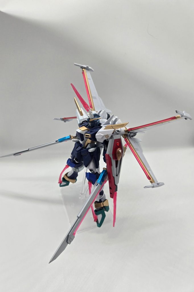 MMWR-X404S/K インフィニットジャスティスガンダムSKインフィニットジャスティスガンダムSへのクガタチ装備時には、機体側のエネルギーコアとクガタチの追加コアを同期させることで出力を安定化。頭部、脚部、背部、対艦刀、シールドに搭載された各ビーム兵装への同時大出力供給を可能とし、全身のビーム兵装を最大出力で展開する。これにより近接戦闘能力は飛躍的に向上する。機動力も大幅に強化され、「紅い幻影(ロッソ・ファンタズマ)」と称される残像現象を発生させるほどの高速運動が可能となる。余談:「MMWR」は『Madoka Magica Walpurgisnacht:Rising』から取っています。設定上は「Multi-purpose Mobile Weapon Research」の略で、非公認研究組織が既存勢力の制式機と自組織の実験機を区別するために使用する独自の開発コード、としています。