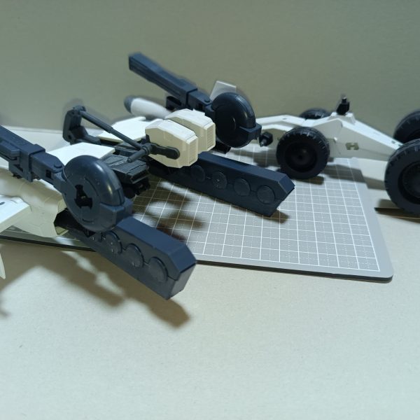 エグザビークルをベースにサブフライトシステムを作製しました。名前の由来はオズの魔法使い主人公ドロシーの履いている銀の靴からです。使用していない3ミリ穴は埋めました。ACには単独飛行しているMSが多いからかSFSが存在していないんですよね。トーラス7.9t、トールギス8.8tに対してレオンは14.5tあるのでリーオー(7.0t)用のフライトユニットでは十分な飛行能力を得られなかった、という設定の元制作しております。左右に新型大出力エンジン2基、ベース部分後方に4基、下部に2基の推進器があるためペイロードが非常に大きく、輸送任務など幅広い運用が可能な設定です。機銃二基とミサイルポッド2基に加えビームキャノンとPDコンテナを懸架することができ、火力支援もお手の物です。セグウェイぽい運用は駐機の固定と超高速戦闘時の運用、操縦桿を折り畳んだ状態はドダイの様な運用を想定しています。マゼラアタックのように上下分割しての運用が可能で、車体の方にはコクピット兼指揮所と居住スペースがあり簡易拠点としても機能します。また、前輪の高さを帰ることで高速走行モードと悪路走破モードを切り替えることができます。基本的に非武装ですが、ビームキャノンとPDを装備することもできます。Cジョイントの部分ですね。車体がある理由として、飛行の燃料消費は多い為、車輪で走行した方が燃費が良いからという設定です。メタ的に言うと、使わないパーツがもったいねー!車体とフライトユニットの接続が不安なので補強案を考えています…。車体前部コクピットの左右に着いている棒とフライトユニットの3ミリ穴をどうにか繋いでステーにする予定です。 (4枚目)
