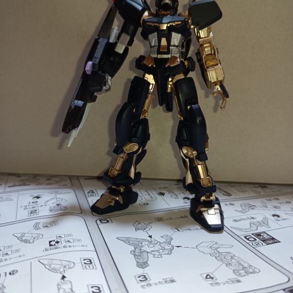とりあえず金と銀と黒をハイスピードで塗装しました！トプ画は公式立ち絵風に。ブリッツのトリケロスは、前腕取付ピンを少し切ることで取り付けられるようになります。トリケロス改のランサーダートは一体成型の為、繋がっている部分が盾の表側から見えちゃうんですよね。なのでパッと見で見えるところまで切り、表側からは3本が独立しているように見せています。そして頭部は昨日作製したパーツを金で塗りアクセントにしています。また、茶色というか不思議な色をした部分はシルバーで塗装しました。結果としてとても好みの色合いになってくれました。残りは全身の赤部分ですが、筆塗りするかマスキングして吹くかで悩んでいます…そしてバックパックから脚部装甲やらを持っていかれた代わりに都牟羽太刀を手に入れたレッドフレームくんもよろしくお願いいたします。（6枚目）