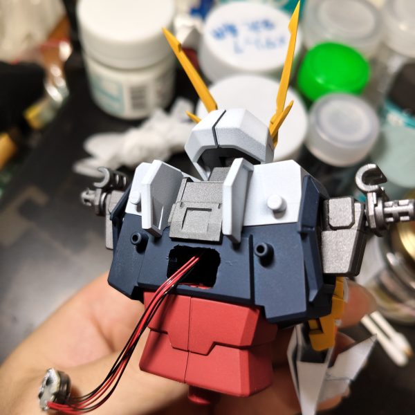 頭部はツインアイ2個とリアセンサー？に1個使用しています。背中にユニットを入れる穴を空け、首を通して頭部まで。首の軸は開通中に折れたので真鍮パイプに交換。一応LEDが故障した時に交換できるように額の分割はそのままにして、首はストレスなく配線できるようにマグネット分割化。背中に空けた穴にバーニア分のユニットも仕込んでいます。（6枚目）