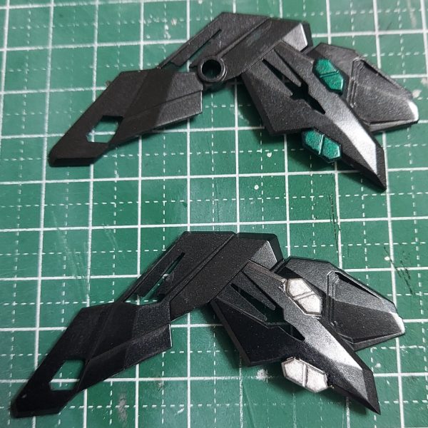 ストフリの外装は思った以上に時間がかかりそうなので、ストフリの製作を再開しました。黒ランナーのパーツはヒケを処理してからランナーごとカラースプレーで塗装。アンダーゲートはゲートを気にせずに一気に吹けるから便利。塗装してトップコートを吹いたら均される――平滑になるかと思ってヒケ処理は600番のヤスリがけしかしなかった結果、思ってたほどではなく質感の差が出てしまいました。1000番までヤスり直して再塗装。その過程で色分けしやすそうなところを見つけました。金で塗れば順当に馴染みそうですが、ほかの色も使いたかったので、持っている塗料瓶を見比べ、写真の2色に絞って実際に塗ってみました。シルバーだと目立ちすぎるから、ここはメタリックグリーンかな。（2枚目）