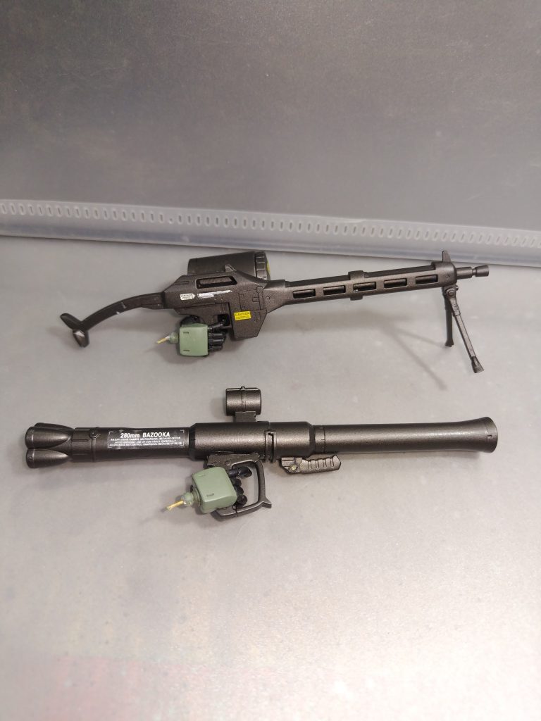 武装上部マシンガンはゲルググからの流用です。設定としてはビームマシンガンの物資不足により、通常弾を発射できるタイプにして、ドラムマガジンとベルト式給弾と差し替えできるイメージです。旧ドイツの電動ノコギリのイメージです。マガジン後部、銃床はザクマシンガンからの流用です。バズーカはF2型の武装でひねりはないです。