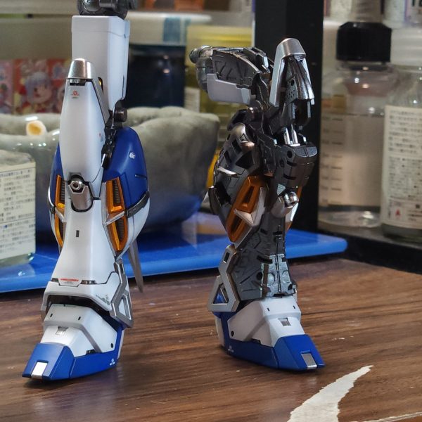 現在制作中のRG Hi-νガンダムです!脚部の組み立てとトップコートまで終わったので、ちょっと嬉しくなって進捗報告です。今回は全体的にリアルで渋めの重厚感を目指してます。外装の塗装:黒立ち上げからのグラデーション!パーツ単体で見てた時は「ちょっとグラデ薄すぎたかな…?」と不安やったけど、組み上げてみたらめちゃくちゃいい感じに馴染んでくれました。最終仕上げはしっとり半ツヤです。内部フレームのこだわり:ここはちょっと実験も含めて、NAZCAのメカサフスーパーヘヴィを贅沢に下地にして、その上からガイアノーツの「スターブライトアイアン」を重ねてみました。メカサフの細かい粒子のおかげでピカピカしすぎず、鈍く重い「鉄!」って感じの質感になって良い感じ。半ツヤ外装の隙間から覗くこの金属感がたまらんです……!膝裏のパイプ類もゴールドとシルバーでちまちま塗り分けました。武器:ハイパー・メガ・バズーカ・ランチャーも一緒に進行中。ティターンズブルーをそのまま吹いたので、単体やと「ちょっと明るすぎたかな?」と思ったけど、なんか大丈夫そうかな。脚部は外装を被せた瞬間に、思った感じの「装甲の半ツヤ×フレームの金属感」のツヤの差が決まって、納得いったかな。残りも組み上げて早く完成させたい!(3枚目)