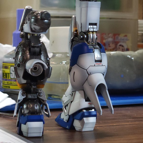 現在制作中のRG Hi-νガンダムです!脚部の組み立てとトップコートまで終わったので、ちょっと嬉しくなって進捗報告です。今回は全体的にリアルで渋めの重厚感を目指してます。外装の塗装:黒立ち上げからのグラデーション!パーツ単体で見てた時は「ちょっとグラデ薄すぎたかな…?」と不安やったけど、組み上げてみたらめちゃくちゃいい感じに馴染んでくれました。最終仕上げはしっとり半ツヤです。内部フレームのこだわり:ここはちょっと実験も含めて、NAZCAのメカサフスーパーヘヴィを贅沢に下地にして、その上からガイアノーツの「スターブライトアイアン」を重ねてみました。メカサフの細かい粒子のおかげでピカピカしすぎず、鈍く重い「鉄!」って感じの質感になって良い感じ。半ツヤ外装の隙間から覗くこの金属感がたまらんです……!膝裏のパイプ類もゴールドとシルバーでちまちま塗り分けました。武器:ハイパー・メガ・バズーカ・ランチャーも一緒に進行中。ティターンズブルーをそのまま吹いたので、単体やと「ちょっと明るすぎたかな?」と思ったけど、なんか大丈夫そうかな。脚部は外装を被せた瞬間に、思った感じの「装甲の半ツヤ×フレームの金属感」のツヤの差が決まって、納得いったかな。残りも組み上げて早く完成させたい!(2枚目)