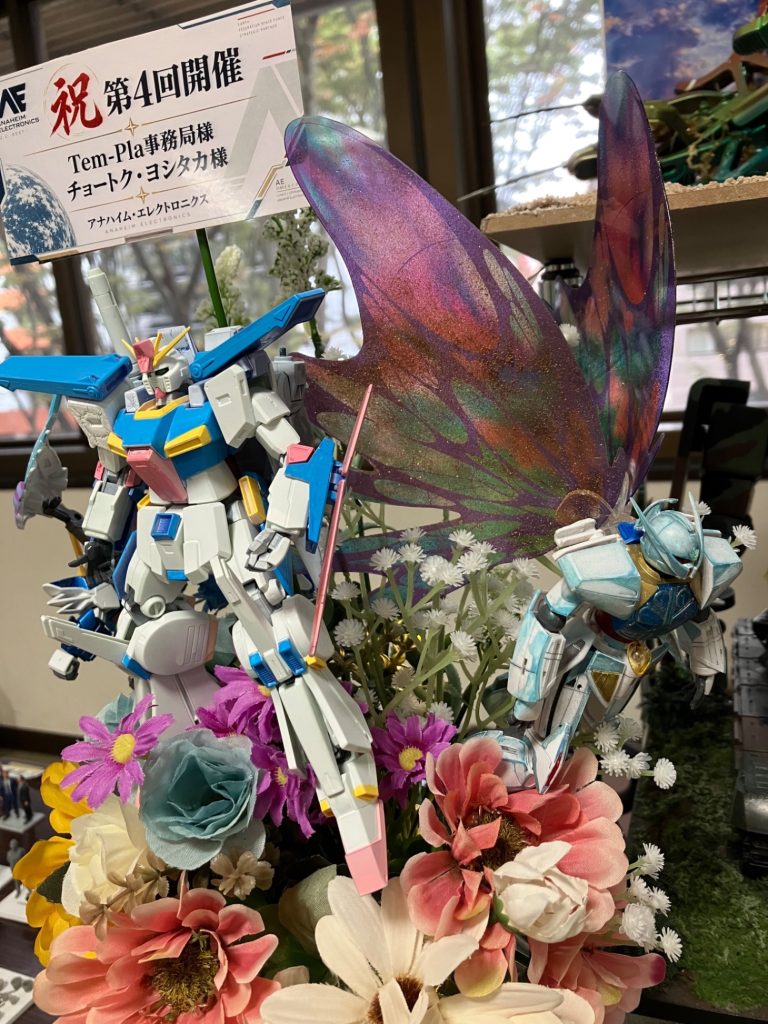 キットとしてはHGターンA、ダブルゼータ、EXSDウイングゼロewを使用。ターンAの羽根にはネイルパウダーをまぶして鱗粉のような表現を目指しました。そしてこの花束の送り主はまさかの大企業です😳笑