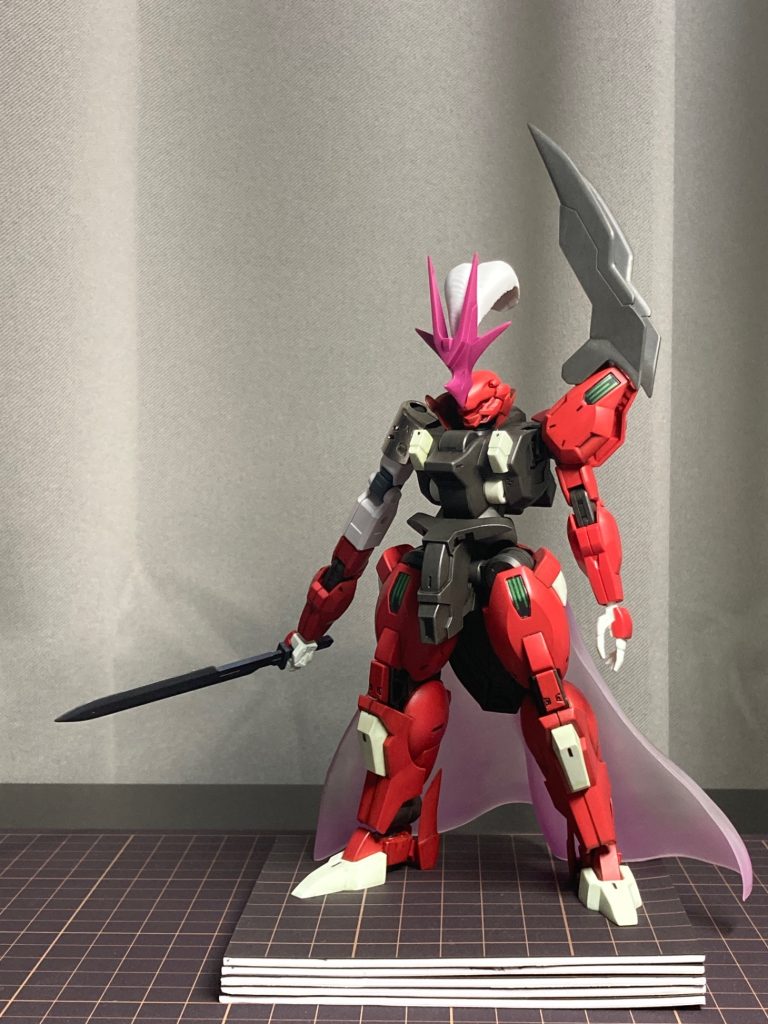 改造がほぼ完了した状態です。グエルらしさを出すため流用したディランザのパーツが騎士っぽく感じたので剣と腰マントを装備、また異形感を出したく右腕を延長しました。あと頭の輪っかは首に引っ掛けて襟に見立てました。剣は境界線機のウェポンセットから右腕はEGガンダムからそれぞれ流用、マントはジャンクフィギュアから剥ぎ取りマグネットで接続しています。あと右肩のメタルは使い捨てライターのキャップです。
