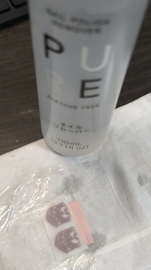 これを切り取って、ずれないようにテープで転写面に貼り、ネイルリムーバーをしみこませ、紙が破けないように透明プラバンを重ねた後、ごりごりと上からなぞって転写させます。Youtubeの例ですとちゃんとしたヘラを使っていましたが、私はリムーバーのお尻でごりごりしました。