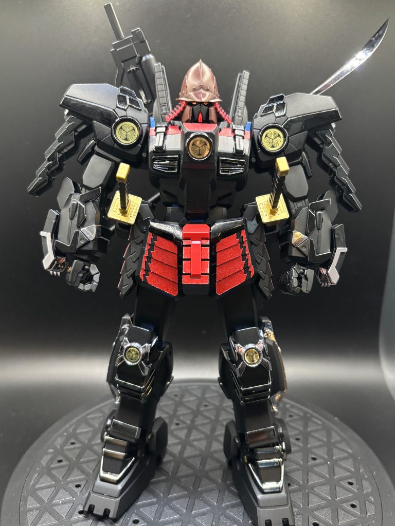 それでは、いつものように見ていきましょう✨まずは、正面です。元のキットは2010年製のMG武者ガンダムマークIIとなります。この特徴的な兜は新規造形となっております(gundam-kao6)通常であれば、武者ガンダムマークIIと言えば2本角の兜ですよね!あれもかっこいいのですが、この兜もなかなか渋いです(gundam-kao7)渋いといえばやはりこのカラーリング✨漆黒の中に輝くシルバーメッキとクロームメッキが高級感を演出しています(zaku-kao2)黒の部分はそのままだとヒケが目立ったので、黒サフを吹いています。マットな感じも出せるので、そのまま生かしました✨徳川の三つ葉葵の家紋もかなり良い感じです👍