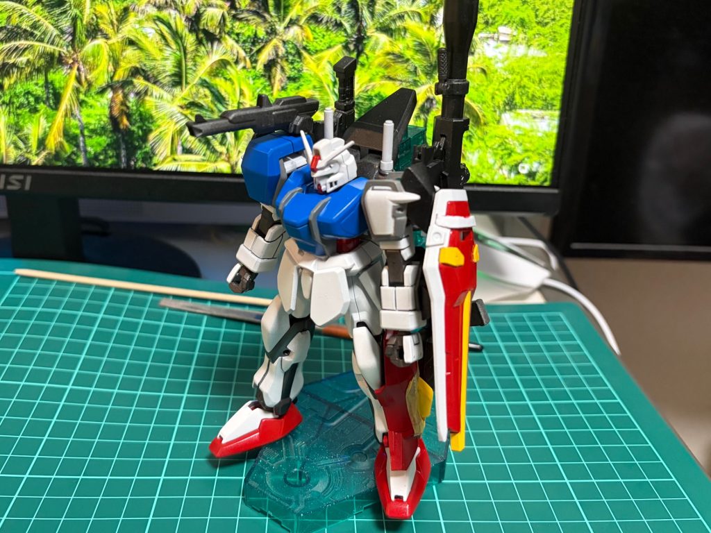 製作中のテストショットその2。追加武器とアサルトシュラウドのフィッティングテストです。この時既にバックパック部分の改造は完了しており、アサルトシュラウドの肩部パーツが見事に干渉してしまった事が発覚。動作に干渉する部分はそのまま置いておくとして、パーツが装着できない部分は放置出来ず作り直しとなりました。
