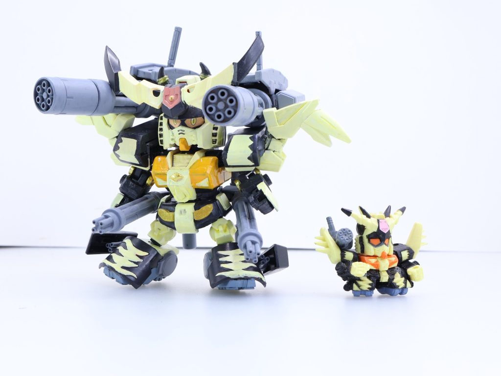 サンダーガンダムの出典(2):というか応募時はS(サンダー)ガンダムだったのね・・・悪っぽいらしい・・・当然ながらSDガンダムフルカラーには一部○伝関係を除き瞳が存在しない。応募イラストもこれに倣う。これは漫画「SDガンダムフルカラー劇場」を参考にして猫目にした。※なおフルカラー劇場はボンボン大判化以前の連載全部を当時家でスクラップしています※配色については応募イラストと実際のフルカラーで(フルカラーの都合上で)色が多少異なるがこれは製作上の独自解釈とした。具体的なざっくりミキシングポイントを・・・角:少年武者烈丸・幼年軍師雷丸頭:SDEX ガンダムをベースに角を生やしたり猫耳をつけたり胸・腰部:SDCSガンダム肩:直江兼続頑駄無とBBウイングゼロカスタムでウイング風に肘関節:無印「GBNW」#13でちらっと説明していたSDフレーム可動肘関節化をようやっと使用。このためフレーム自体はSDフレーム手首:ビルドハンズ膝:直江兼続頑駄無足首:蒼天丸紅天丸でアーマーを作り足元にプラ板でキャタピラっぽいものを貼ったBBヘビーウェポンキャプテンガンダムガトリング:ジャイアントガトリング二丁(うち一丁は「GBNW:Nexus」#17・魔王信長ルシフェルの魔王銃を塗り替え)・パワードアームズパワーダーバックパック:グフR35のロケットブースター他パテ埋めなどとなっています・・・ちなみに頭自体は初代ガンダムと当初から似ている印象を受けます。メインカメラは元イラストオレンジ、フルカラーでは塗り分けなしでしたが元キット(実はハローキティ付属の方なのだ)のグロスインジェクションを使いたくて赤のままです。
