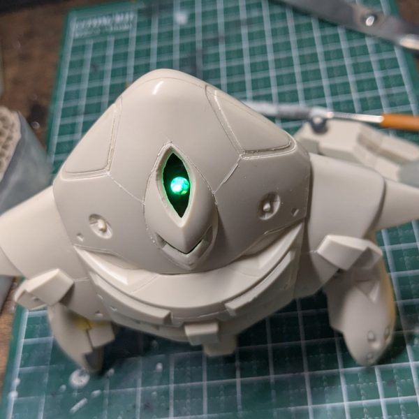 数日試行錯誤しながらLED発光モノアイユニットを本体に設置する工作とかしてみたりしてました。最初に作ったモノアイはあれこれしてたらLEDの根本のラインがぽきっと折れてお亡くなりになりました。縦横2軸の可動アームとかつくったのに。。。私の心も折れたので、結局いつものとおりDAISOプチブロックさんのボールジョイントを頼りにする方向に逃げました。電源のON/OFFは自作適当ボックスへの電池の抜き差しという割り切った仕様。スイッチ付きの電池ボックスも買ったんですがちょいとサイズが大きくておさまらなかった。グーンさんの大きな身体のおかげもあって電池含めてぜんぶ内側におさまるようになりました。工作は雑ですが。まあこれでも通常モードと巡行モードのモノアイ位置移動ができるので良いことにします。問題ナシ。あと基部にブロックを使ったのでモノアイユニットが脱着できるのはメンテナンス考えると良かったかもしれない。次は足裏の肉抜き埋めとか形状修正とかかなあ。(3枚目)
