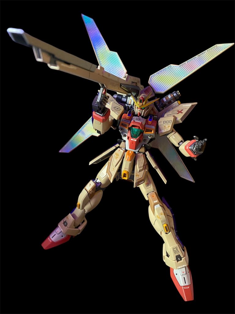最後に箱絵と同じポーズで！まさに幼少期に夢中になっていた平成ガンダムシリーズドンピシャ世代なのですが、その中でも最も好きだったシリーズがガンダムXです。Gガンは所謂格闘漫画的テイストに振れ過ぎていて、Wは政治的な勢力図がコロコロ変わり分かりにくい…平成シリーズでは最も宇宙世紀的な二大勢力が宇宙戦争をやっていた世界観だったので、子供心にも分かり易かったのかも知れません。しかし、アニメは見ていたハズなのに、イマイチ途中から記憶無い…。なるほど、途中から放送時間が変わったり、打切りで話数短縮だったとかいう大人の事情を知ったのはだいぶ後になってからだったかも…😅しかし！！そんな自分でも確かにストーリーの記憶が有るのは、当時、清く正しいボンボン読者だったからなのであります❗️ときた光一先生の漫画版は毎月欠かさず読んでたし、最終回の一枚絵は今でも忘れない！そして、最も強く印象に残っていたのが、本編終了後に掲載された、「ニュータイプ戦士・ジャミル・ニート」のお話でした！本編のストーリー完結後に、第一話に繋がる前日譚を描くという、後にスターウォーズなどで人気を博する所謂エピソード0方式。恐らく、本来放送と連動して1年間の連載予定だったものが、アニメ打ち切りとなった為に、穴埋めとして急遽用意され企画…だったのかな？ですが、前後編の2話で描かれたこちらのお話の完成度がとても素晴らしいのです👍という事で、今回の機体設定・ストーリーは、このお話の隙間をさらに補完するようなイメージで、劇中最強のNTパイロット・ジャミルの教官を務めたルチルは何故精神を崩壊してLシステムに組み込まれたのか？そして、サテライトキャノンほどの戦略兵器ならば、必ずその威力を検証するための実験が行われたはず…という点に着目し、史上初めてのサテライトキャノン試射を舞台に描かせて頂きました。30年ぶりに作るGXは、やっぱりめちゃくちゃカッコいい❗️少年時代に夢中になっていたアニメが、周年でこうやって再注目されて盛り上がるのは、すごく感慨深く嬉しいですね！キット化にはあまり恵まれてこなかったガンダムXシリーズ。バンダイさん！宇宙革命軍のMSも何か一つキット化オナシャス❗️